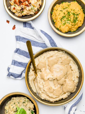 four bowls of dairy free mashed potatoes with different toppings.
