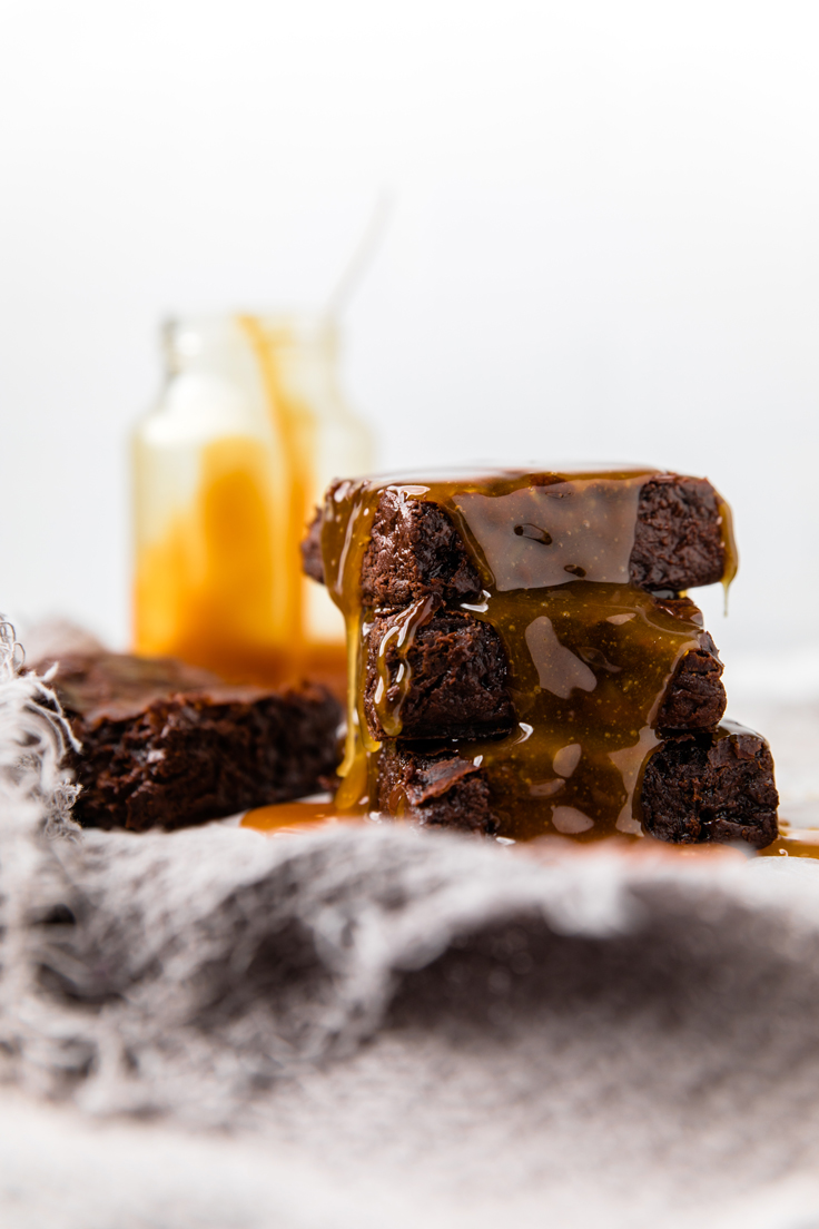 stack of three dairy free brownies with caramel.