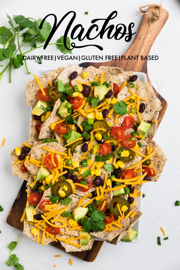 the words nachos dairy free vegan gluten free plant based overlayed on a board of nachos.
