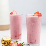 two dairy free strawberry banana smoothies in glasses.