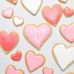Dairy free heart shaped sugar cookies with pink icing, middle one says love u.