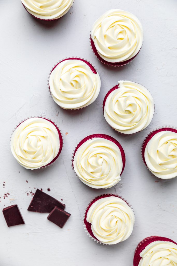 seven dairy free red velvet cupcakes with cream cheese frosting.