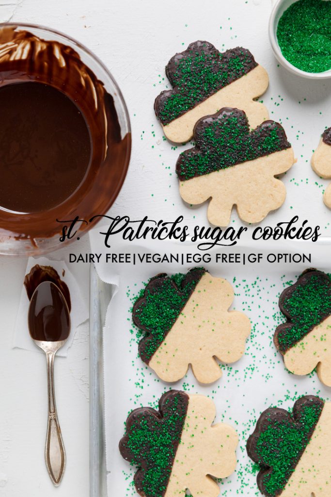 the words st patricks sugar cookies overlayed on shamrock cutouts of dairy free sugar cookies.