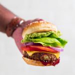 A hand holding the ultimate vegan black bean burger.