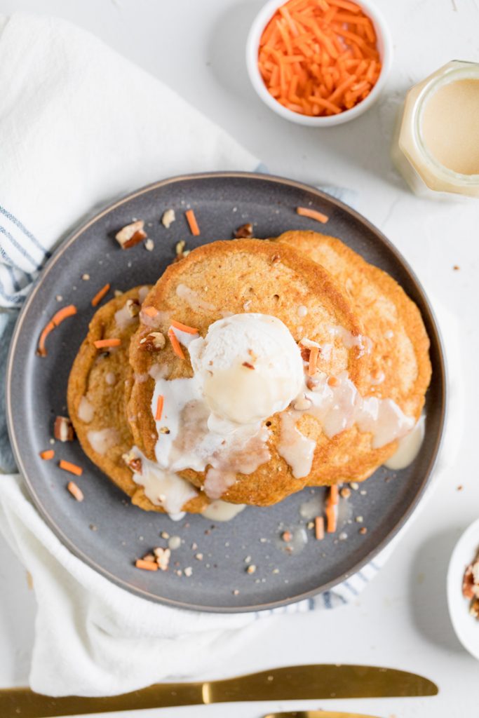 a plate vegan carrot cake pancakes with whipped topping.