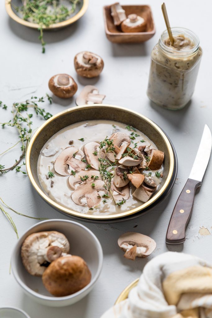 a bowl of vegan cream of mushroom soup with fresh thyme and baby bella mushrooms.