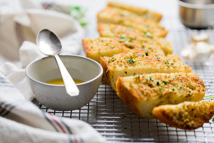 slices of vegan garlic bread and a bowl of melted butter.
