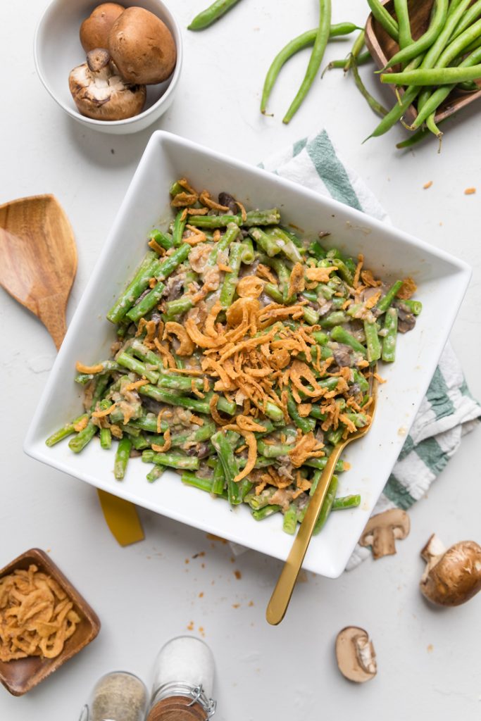 A serving dish of vegan green bean casserole on a table.
