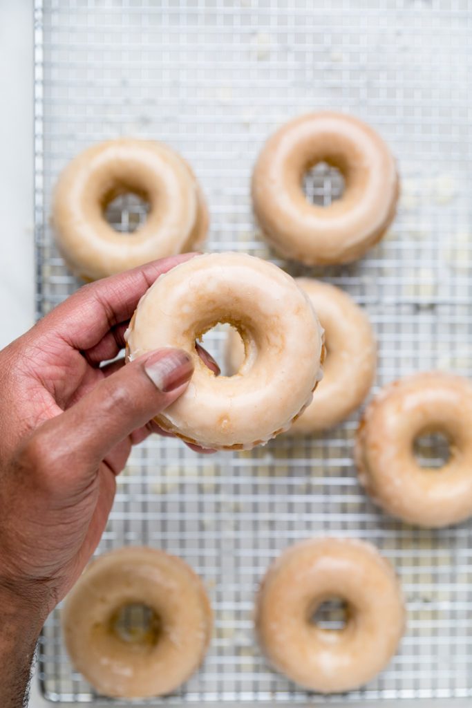 A single glazed vegan donut in a hand.