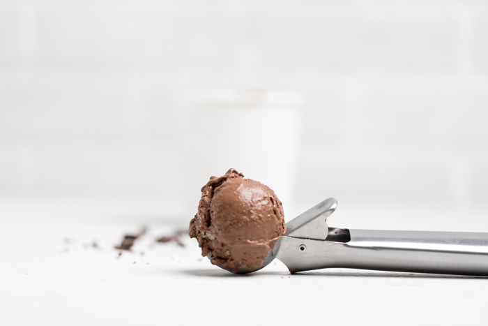 an ice cream scooper filled with vegan chocolate ice cream.