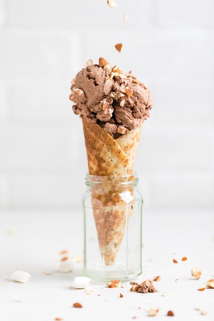 a jar holding a cone filled with vegan rocky road ice cream.
