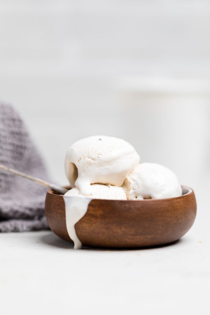 a wooden bowl of homemade vegan vanilla ice cream.