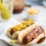 two cooked homemade vegan hot dogs on a plate.