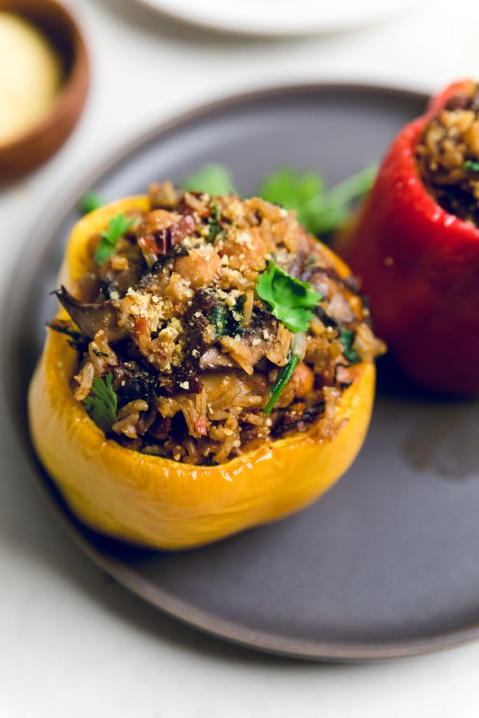 a plate with a yellow Tuscan style vegan stuffed pepper.