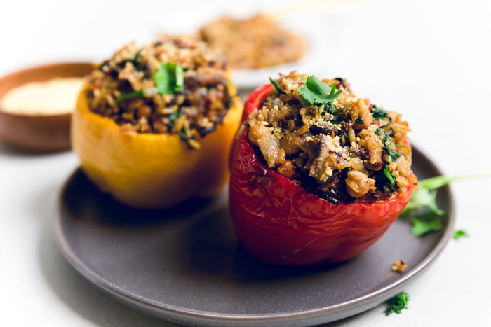 a plate with a yellow and red Tuscan style vegan stuffed peppers.