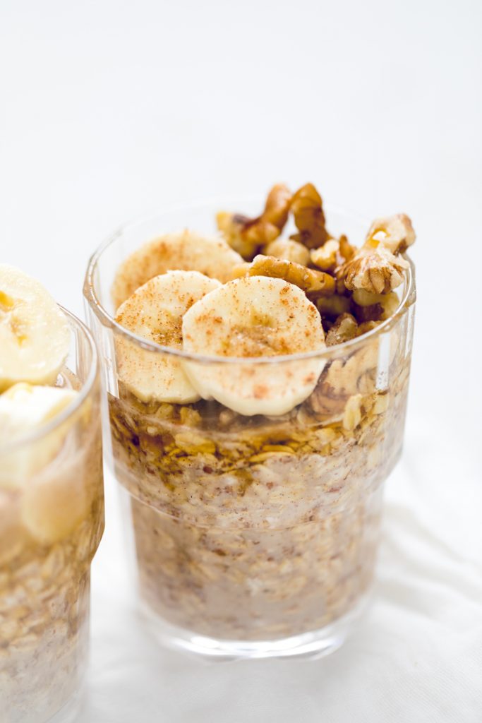 vegan banana bread overnight oats in a glass jar with toppings.