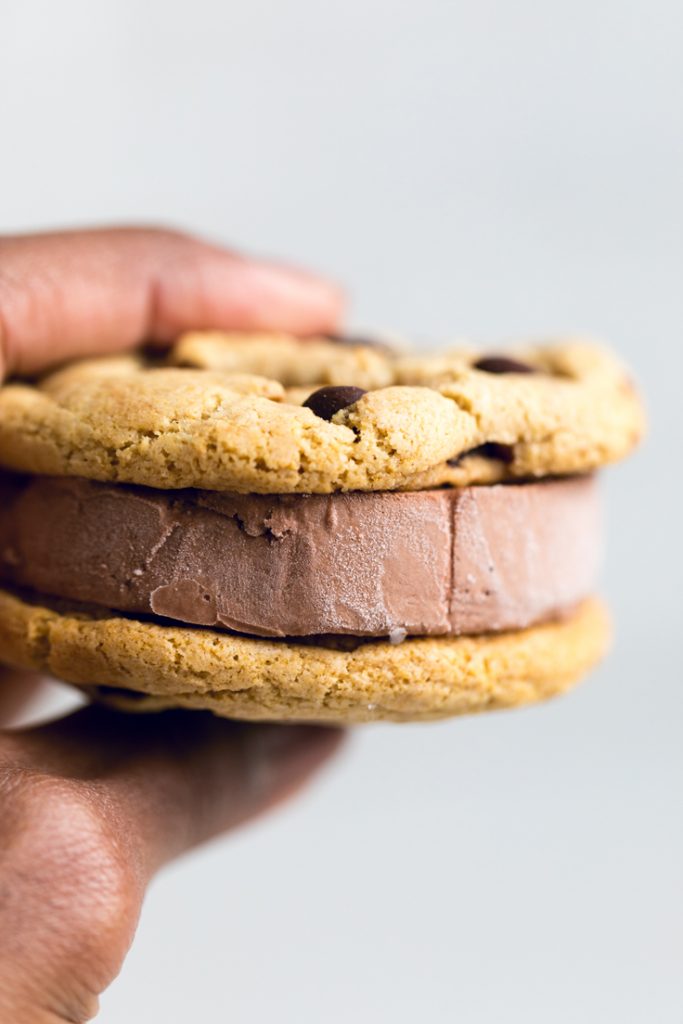 a hand holding a vegan chocolate ice cream sandwich.