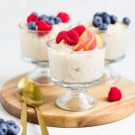 vegan rice pudding in three individual glass serving cups on a wooden board.