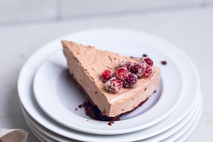 a slice of no bake vegan chocolate cheesecake on a white plate.