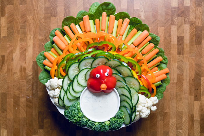 Thanksgiving turkey veggie tray with ranch dressing in a white bowl. 