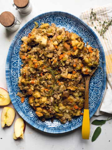 a blue serving plate with vegan apple and sausage stuffing.