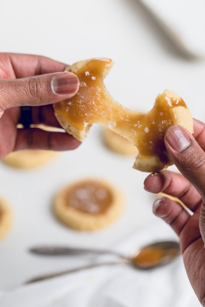 a person pulling apart a vegan salted caramel cookie.