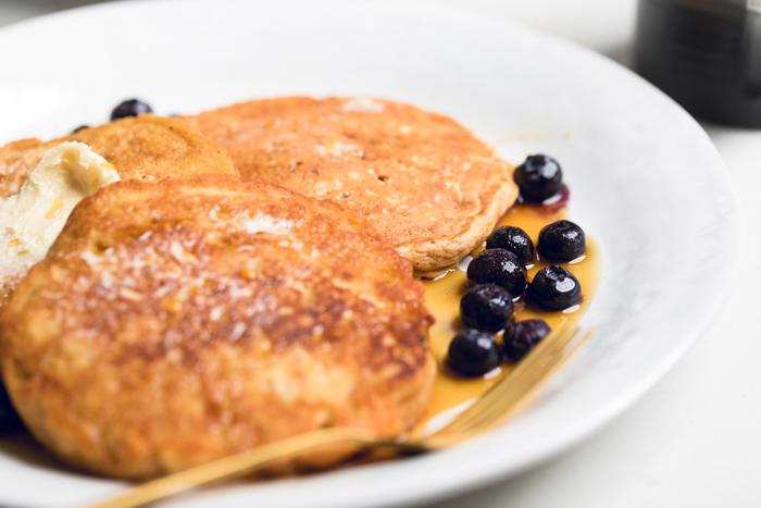 vegan sweet potato pancakes with syrup and fresh blueberries.