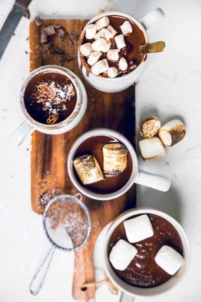 Four cups of Vegan Hot Chocolate on a wooden cutting board. 