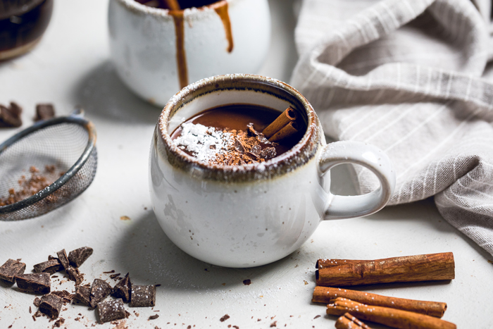 A mug of vegan hot chocolate with maple syrup, cinnamon and brown sugar.