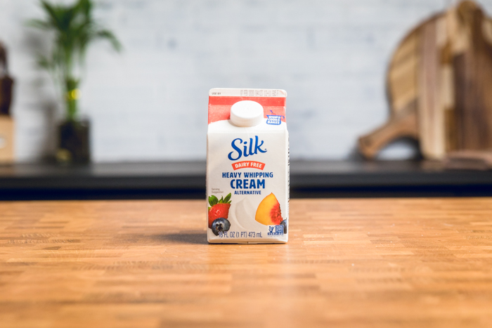 A carton of silk heavy whipping cream standing on a table.