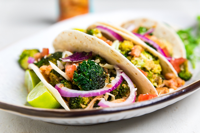 A Korean inspired vegan broccoli taco with red onions.