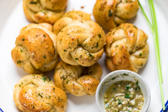 Vegan garlic knots stacked on a plate.