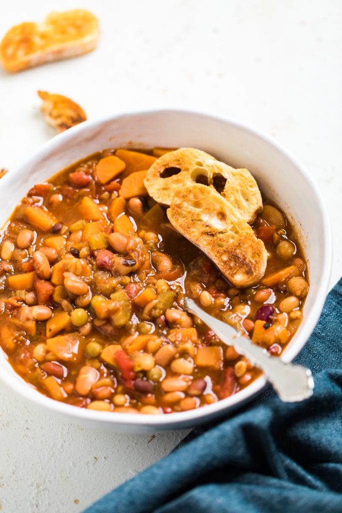 Instant pot vegan bean soup with crunchy bread on top.