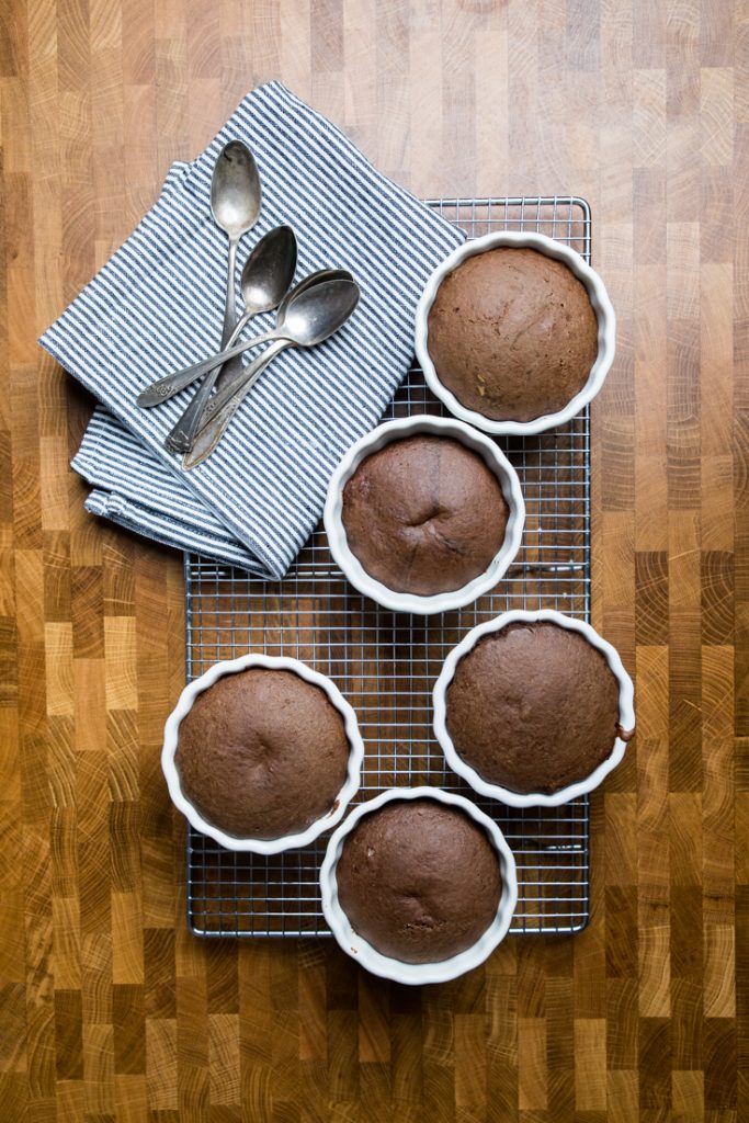 Five vegan chocolate lava cakes in ramekins. 