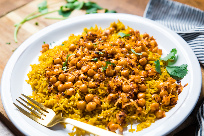 A plate of spicy coconut chickpeas and turmeric rice with cilantro. 