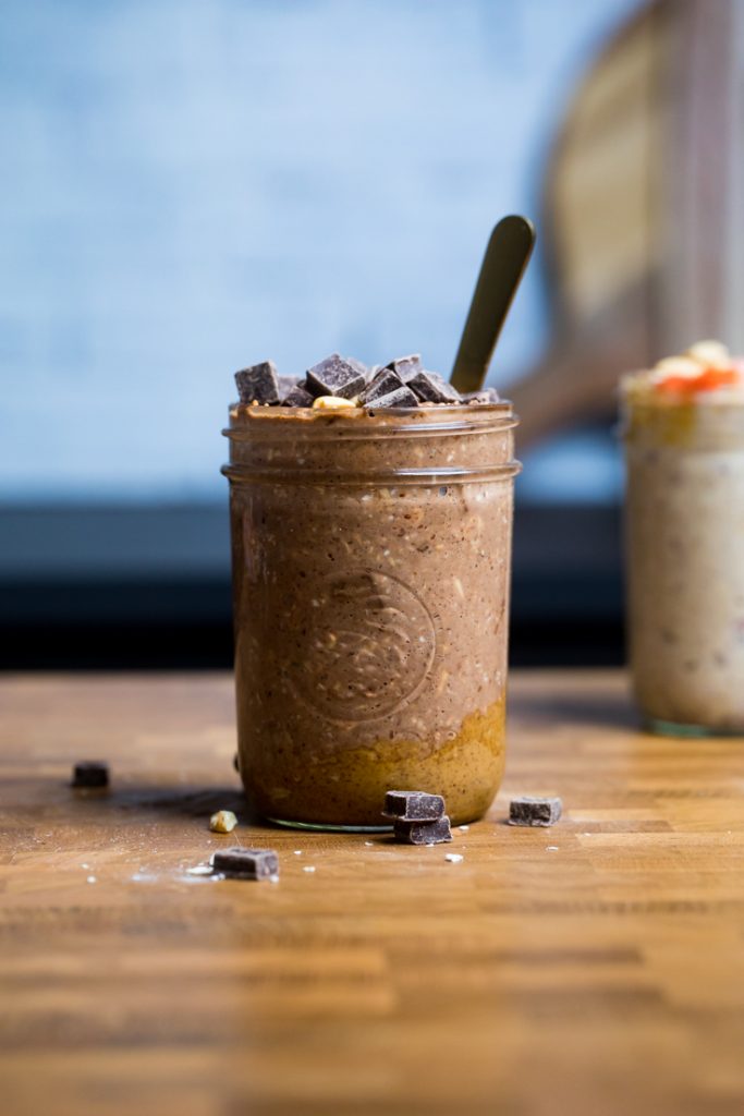 A mason jar filled with vegan chocolate peanut butter overnight oats with a spoon inside.
