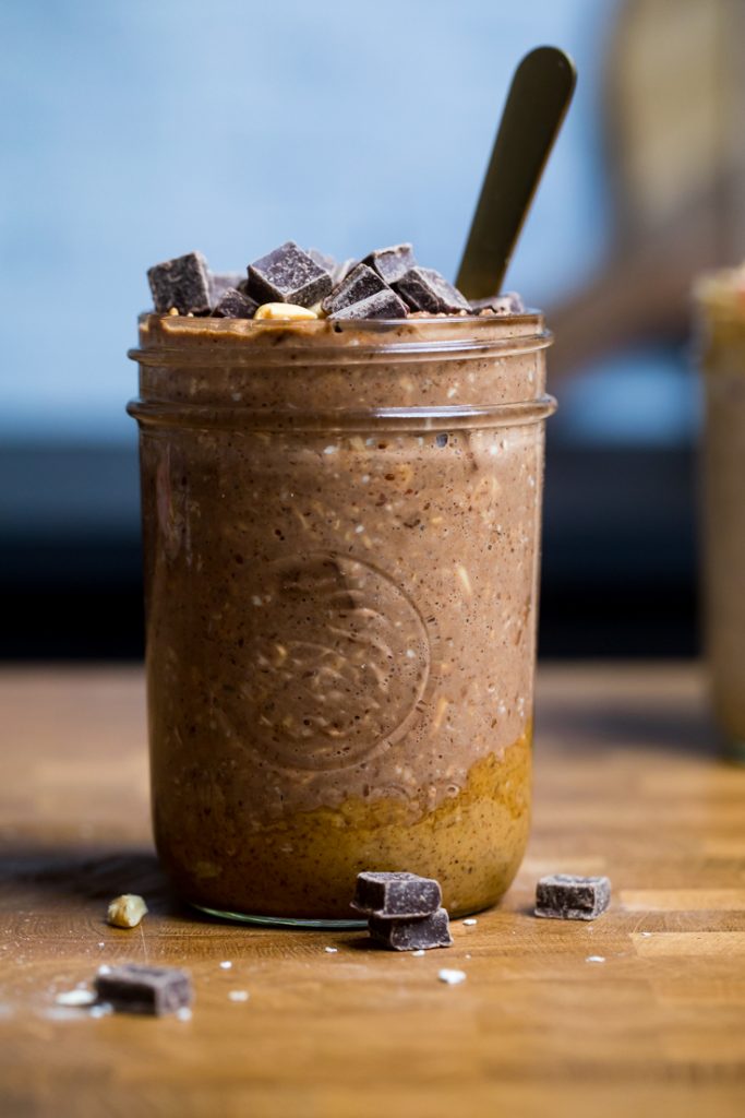 A serving of vegan chocolate peanut butter overnight oats topped with chocolate chunks.