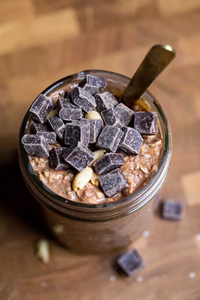 Top of a jar of vegan chocolate peanut butter overnight oats with chocolate chunks and peanuts.