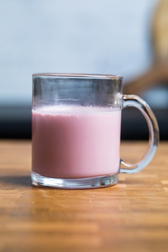 A glass of Homemade vegan strawberry almond milk.