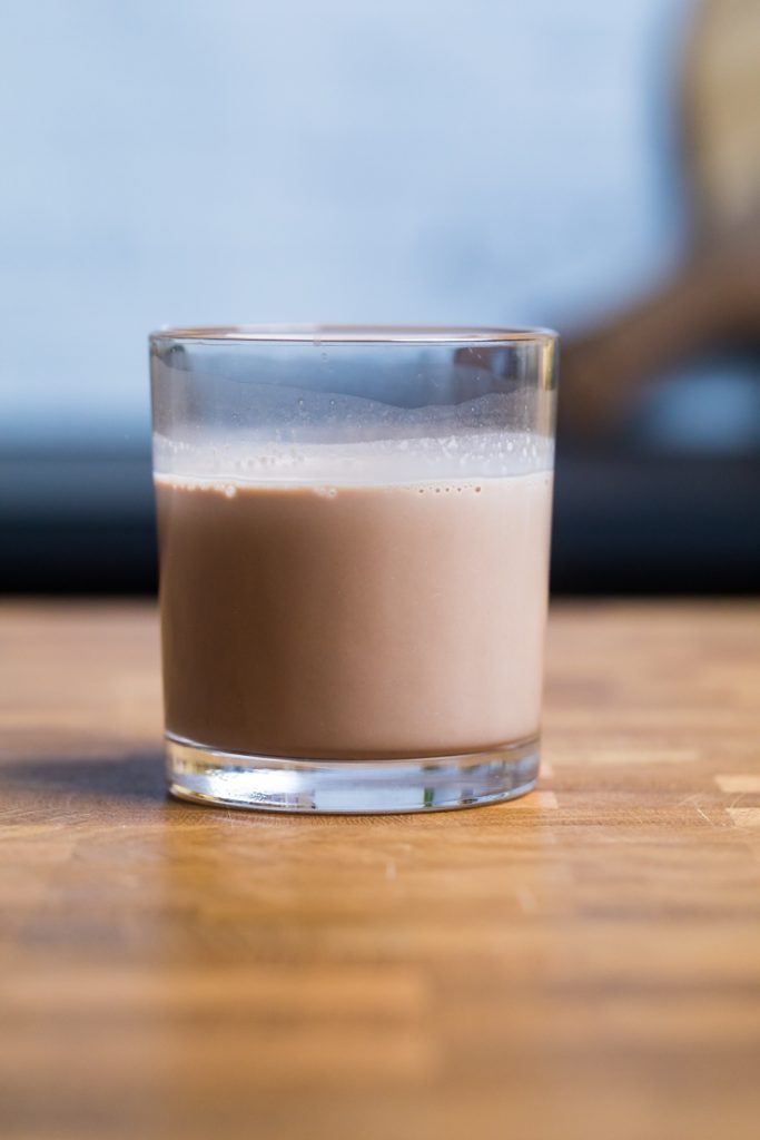 A glass of homemade vegan chocolate almond milk.