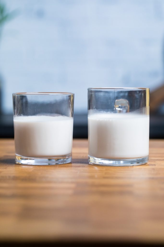 Two glasses of homemade vegan almond milk side by side.