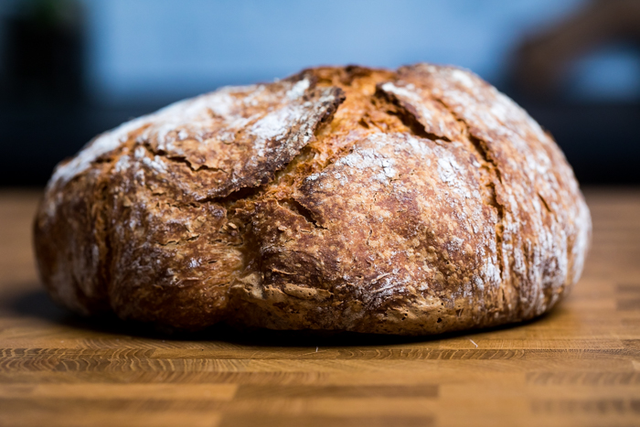 A loaf of crunchy vegan artisan bread resting on a table.