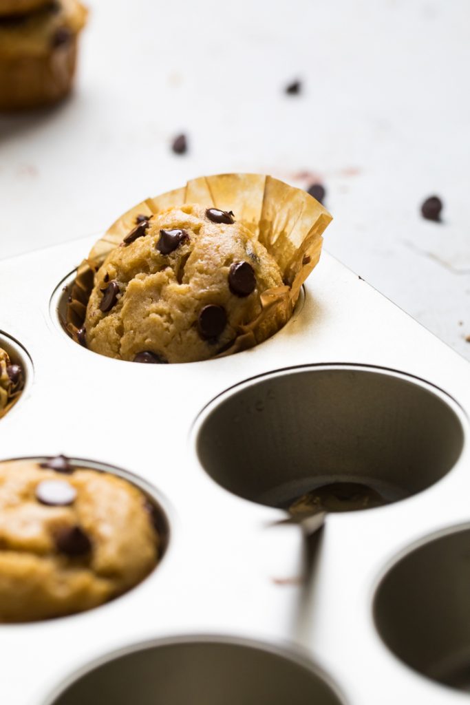 A vegan chocolate chip muffin in a muffin tray.