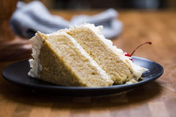A double layer slice of vegan vanilla cake on a plate.
