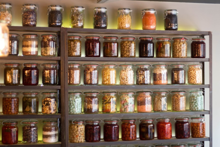 Mason jars full of food on a shelf.