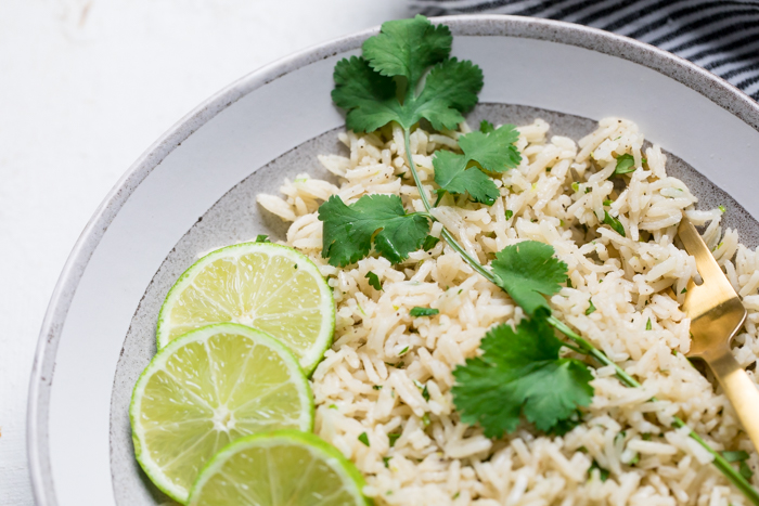 Vegan cilantro lime rice topped with fresh cilantro and lime slices.