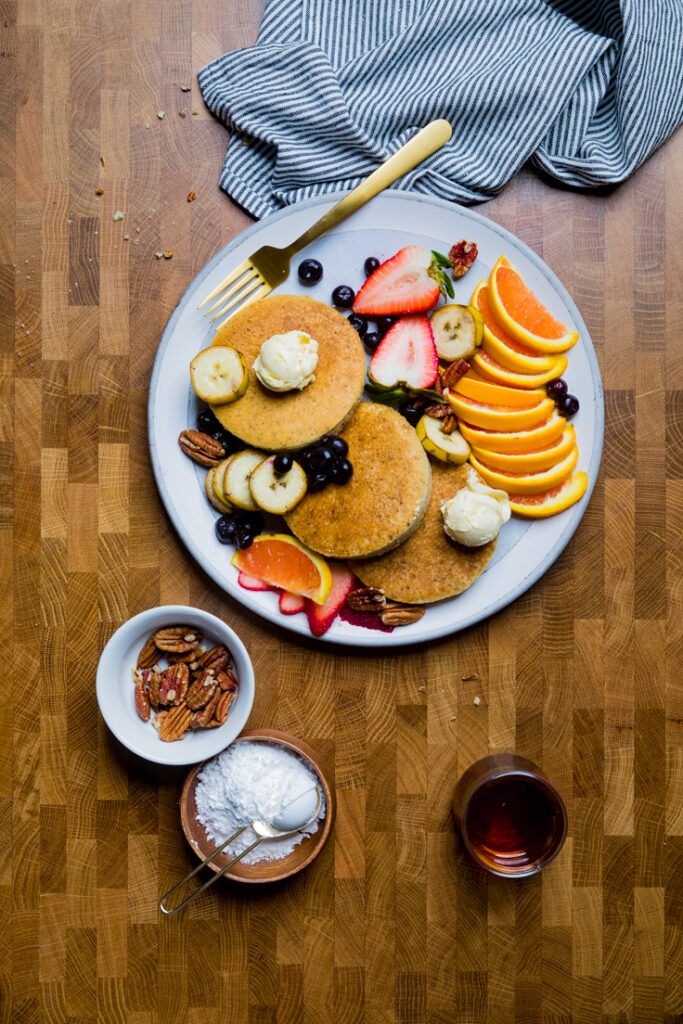 Vegan Japanese souffle pancakes on a plate with fresh fruit.