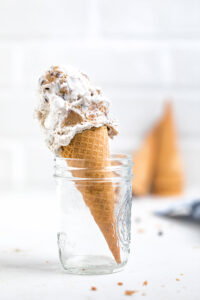 A cone of vegan cookie dough ice cream in a glass.