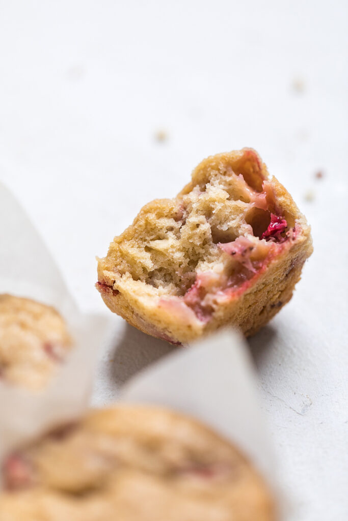 Half of a vegan strawberry muffin to show fluffy texture.