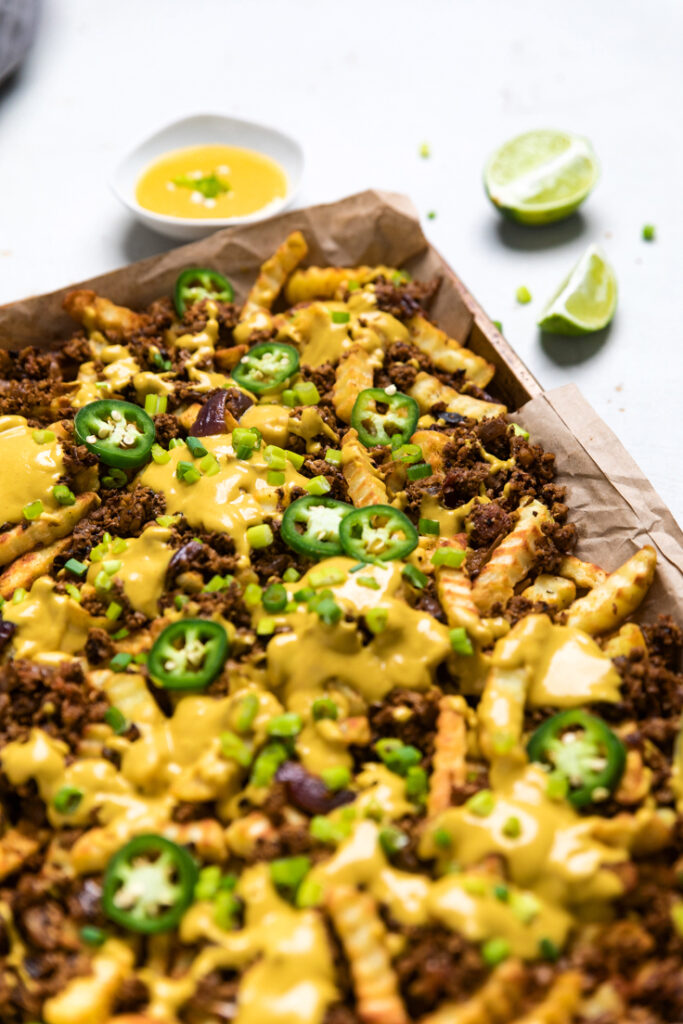 A tray of vegan walnut meat cheese fries with fresh jalapenos.